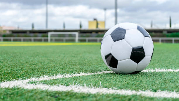 SOCCER BALL ON THE GRASS IN THE FOOTBALL FIELD.